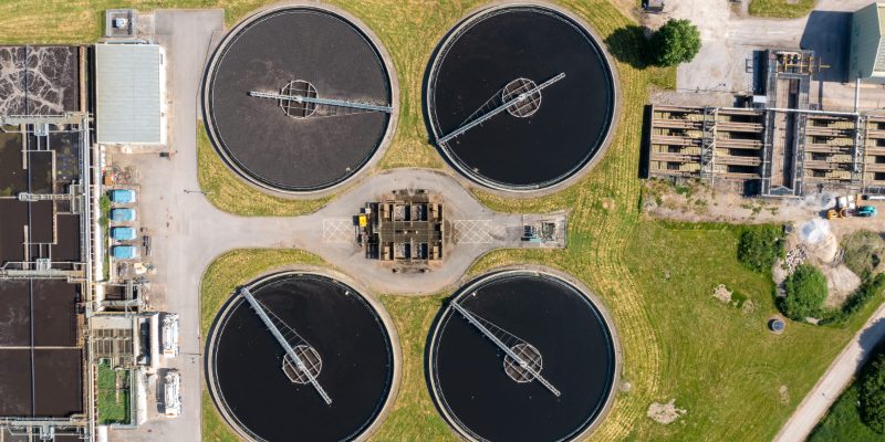 UK water recycling plant aerial — circular sedimentation tanks at a treatment works in West Yorkshire, the kind of infrastructure investment underpinned by Ofwat's PR24 Final Determinations.