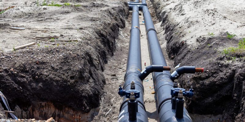 Twin pre-insulated district heating mains under installation — the infrastructure that the Heat Network Zoning Act 2024 will scale across England's first designated zones.