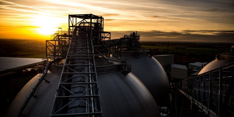 Drax Power Station, Selby — biomass storage domes and conveyor at sunset. The site where the confirmed BECCS investment will integrate with East Coast Cluster CO₂ transport.