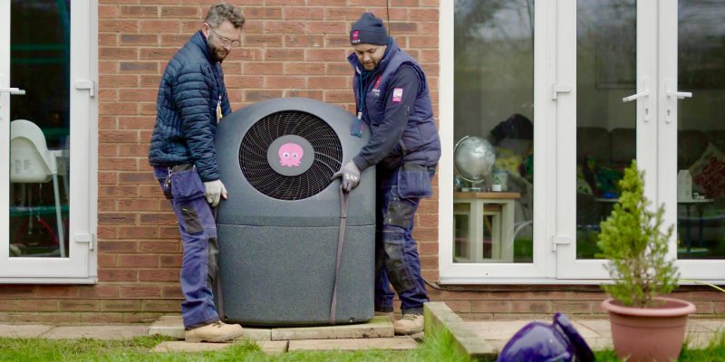 Octopus Energy engineers installing a Cosy Octopus air-source heat pump at a UK home — Octopus is the UK's largest heat pump installer, leading the ramp under the Boiler Upgrade Scheme and the new Clean Heat Market Mechanism.